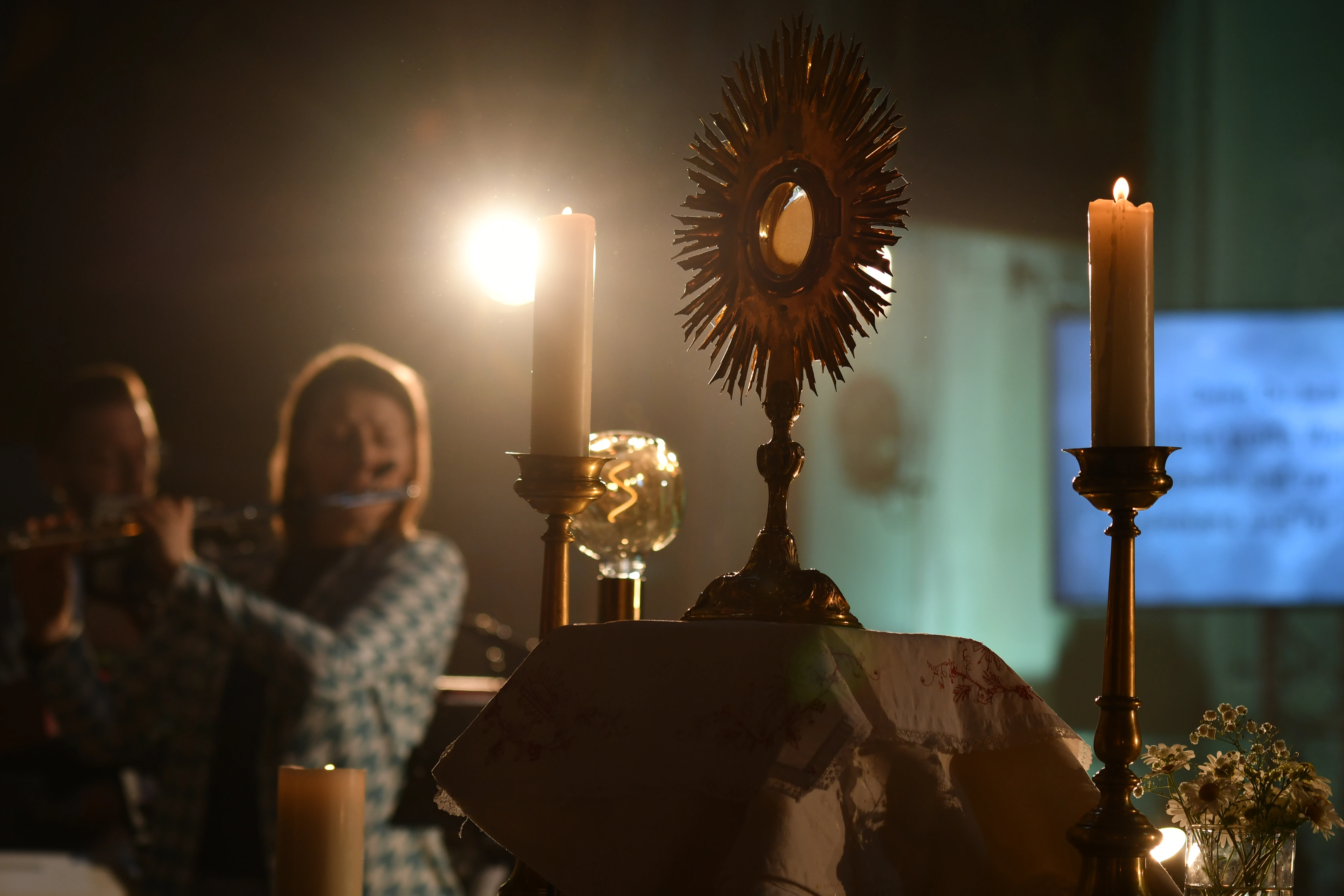 A monstrance with the Blessed Sacrament is displayed on the altar during Eucharistic adoration at a Loretto Community Pentecost event accompanied by live music.?w=200&h=150