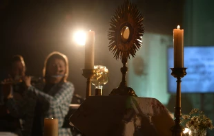 A monstrance with the Blessed Sacrament is displayed on the altar during Eucharistic adoration at a Loretto Community Pentecost event accompanied by live music. Credit: Loretto Gemeinschaft