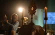 A monstrance with the Blessed Sacrament is displayed on the altar during Eucharistic adoration at a Loretto Community Pentecost event accompanied by live music.