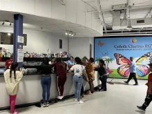 Volunteers and staff with Catholic Charities of the Rio Grande Valley assist Latin American and Haitian migrants at a migrant shelter in McAllen, Texas.