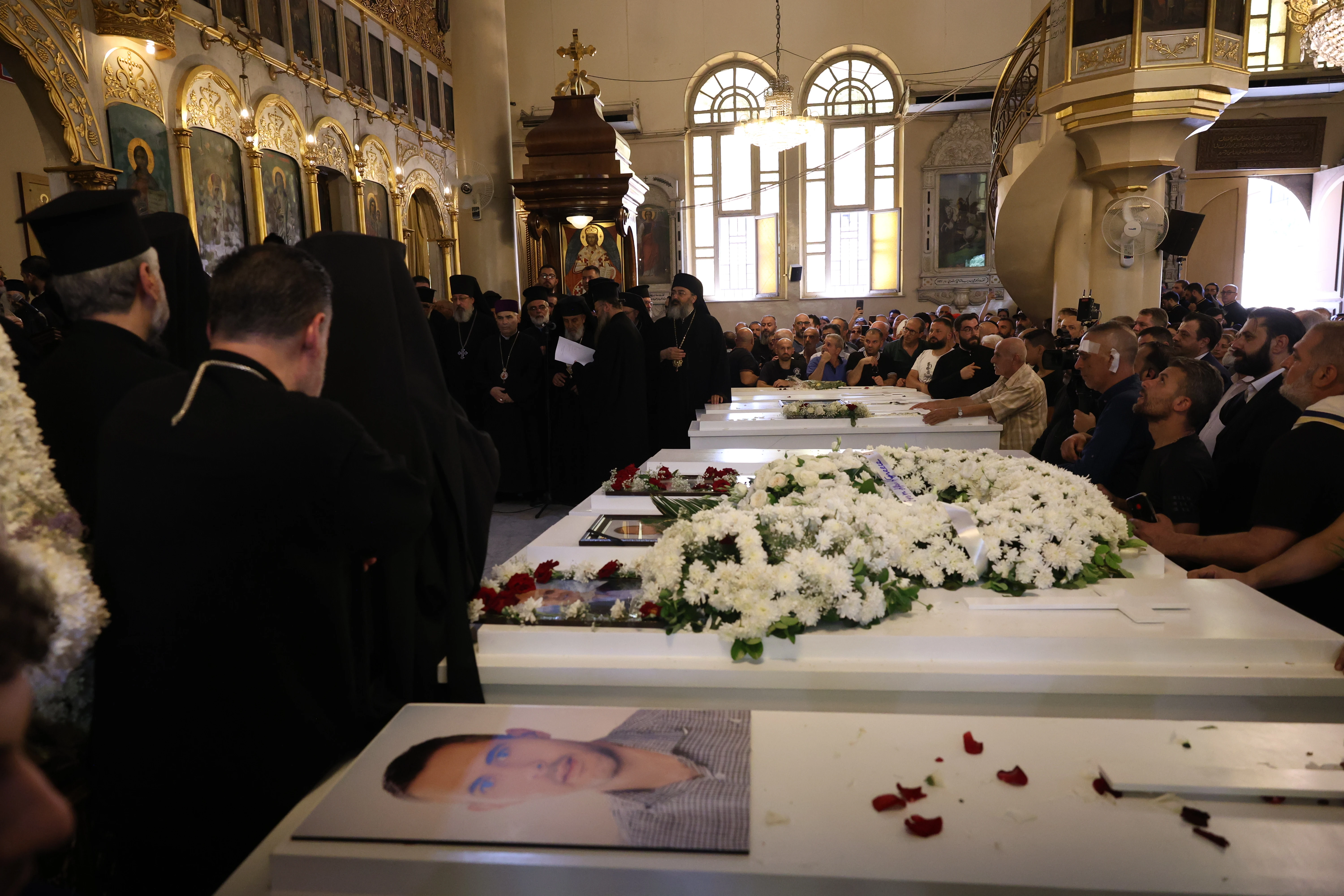Mourners gather at the Church of the Holy Cross in Qassaa, Damascus, on June 24, 2025, around white caskets of some of the worshippers who lost their lives in a terrorist attack at the Mar Elias Church in the Dweila neighborhood of Syria’s capital on Sunday, June 22, 2025.?w=200&h=150