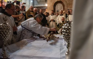 The custos of the Holy Land, Father Francesco Patton, anoints the statue of Jesus on the Stone of Anointing during the ceremony known as the “funeral procession” on Good Friday night 2024. According to the tradition and the Status Quo, on the evening of Good Friday — both Catholic and Orthodox — the rite of preparing Jesus’ body for burial is reenacted on this stone during the so-called “funeral procession.” Credit: Marinella Bandini