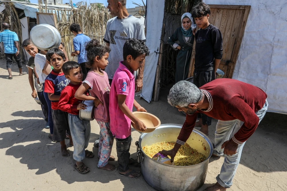 Charitable organizations distribute food to displaced people in shelter tents in Deir al-Balah in the central Gaza Strip on June 9, 2024.?w=200&h=150
