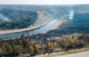 An aerial view shows charred remains on the side of the road beside the highway in Enterprise, Northwest Territories, Canada, on Aug. 20, 2023. Enterprise and Hay River were put on evacuation orders prior to the city of Yellowknife. The town of Enterprise, Northwest Territories, was burned to the ground by forest fires. Credit: ANDREJ IVANOV/AFP via Getty Images