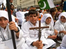 A Christian boy holds a crucifix during a protest in Karachi on Aug. 22, 2023, to condemn the attack on churches in Pakistan. More than 80 Christian homes and 19 churches were vandalized in an hourslong riot in Jaranwala in Punjab province on Aug. 16 after unverified reports that a Koran had been desecrated.