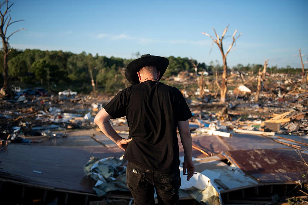 Tony McFall wears his father’s cowboy hat while looking over the debris of the house of his father and step-mother, who lost their lives during the tornado in the neighborhood of Sunshine Hills on May 17, 2025, in London, Kentucky. A tornado struck communities in Somerset and London, Kentucky, leaving over 10 dead and more injured.?w=200&h=150