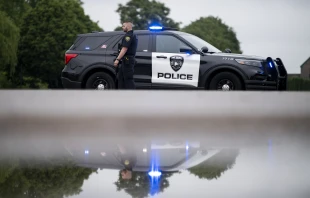 A Brooklyn Park police officer looks on while guarding the entrance to a neighborhood on June 14, 2025, in Brooklyn Park, Minnesota. Credit: Stephen Maturen/Getty Images