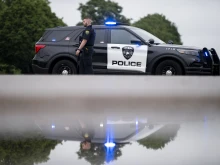 A Brooklyn Park police officer looks on while guarding the entrance to a neighborhood on June 14, 2025, in Brooklyn Park, Minnesota.