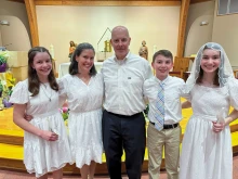 The McCoppin family (from left): Alyssa, Courteney, James, Rhys, and Kelly, poses for a photo after entering the Catholic Church at the Easter Vigil on April 8, 2023, at Sacred Heart Church in Manassas.
