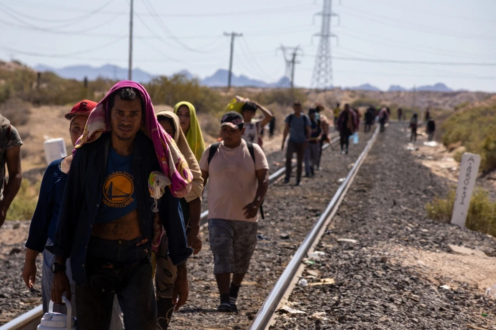 Migrants walk alongside the railroad tracks after dismounting from the “La Bestia” train, which they rode through Mexico to reach the Mexico-U.S. border near Chihuahua, Mexico.?w=200&h=150