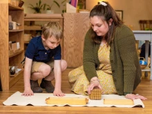 Cassandra Baker, now a coordinator for the Catholic Montessori Institute, presents a math lesson introducing the decimal system to a 4-year-old student in spring 2023 at the Christ the King Catholic Montessori Grade School in Mandan, North Dakota.