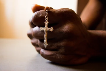 Hands praying rosary
