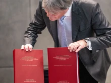 Ulrich Wastl shows copies of the abuse report for the Diocese of Bolzano-Bressanone at its presentation in Bolzano, Italy, on Monday, Jan. 20, 2025. The 635-page document, published in both Italian and German, details investigations into abuse cases spanning from 1964 to 2023.