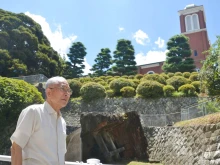 Catholic Shigemi Fukahori stands in front of the former bell tower of the Urakami Cathedral in Nagasaki, Nagasaki Prefecture, on July 17, 2013.