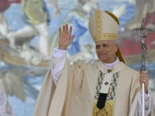 Pope Leo XIV waves during the inaugural Mass of his pontificate, held in St. Peter’s Square on May 18, 2025. He stands in front of a Flemish tapestry depicting the dialogue between Jesus and Peter after the miraculous catch of fish.