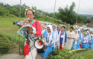 Women baptized by Prem Bhai climb to his memorial singing devotional songs during a 2018 observance of the Catholic missionary. Credit: Anto Akkara